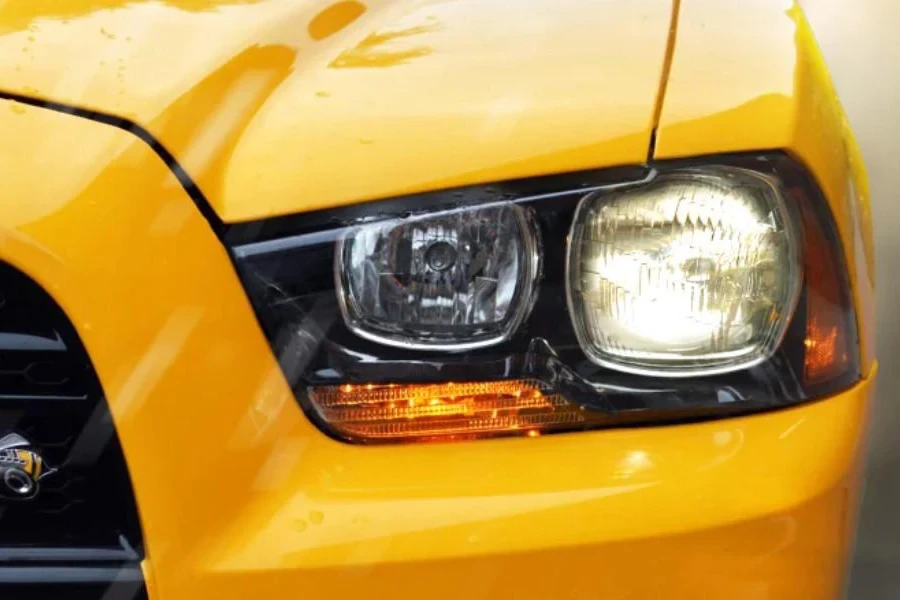 Un coche amarillo con faros halógenos.