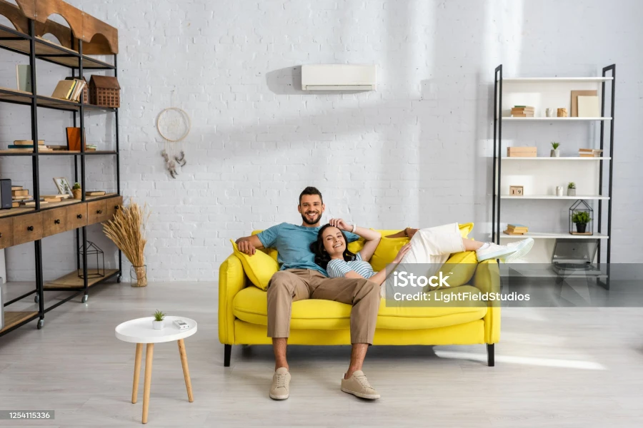 Sala de estar chique com sofá amarelo iluminado pelo sol