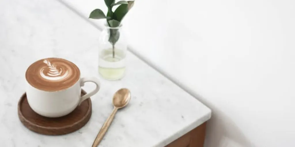 Café e planta na mesa de mármore