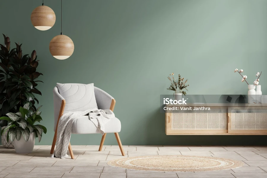 Dinding hijau dengan kursi berlengan abu-abu dan dekorasi di ruang tamu