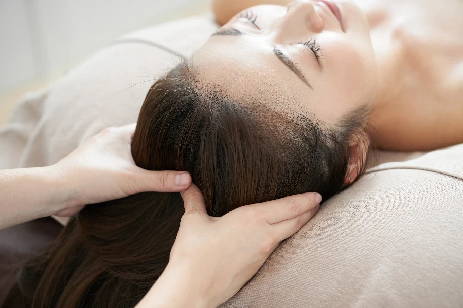 Mulher japonesa recebendo massagem shiatsu na cabeça em um salão de beleza japonês