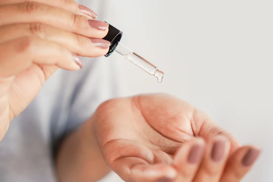 Nahaufnahme einer Frau, die ein Retinol-Produkt auf ihre Hand fallen lässt