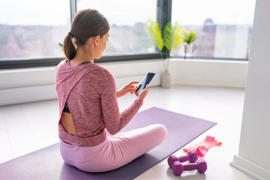 Faire de l'exercice en restant à la maison, une femme regardant des vidéos de fitness