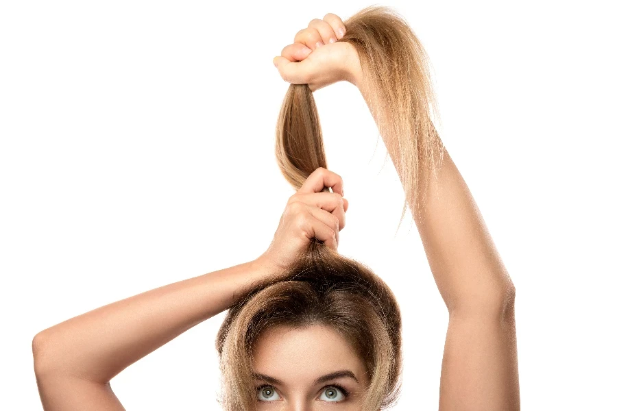 Une belle femme est très heureuse des progrès de la croissance de ses cheveux