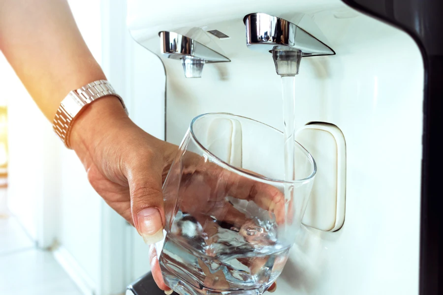 Ein Glas sauberes Süßwasser und ein Satz Filterkartuschen auf einem Holztisch