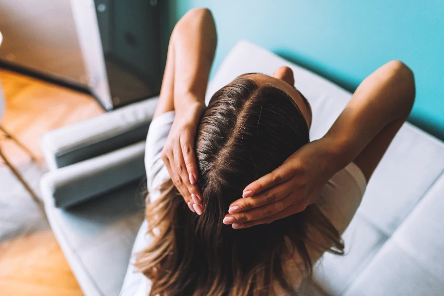 Giovane donna castana che mostra i suoi capelli