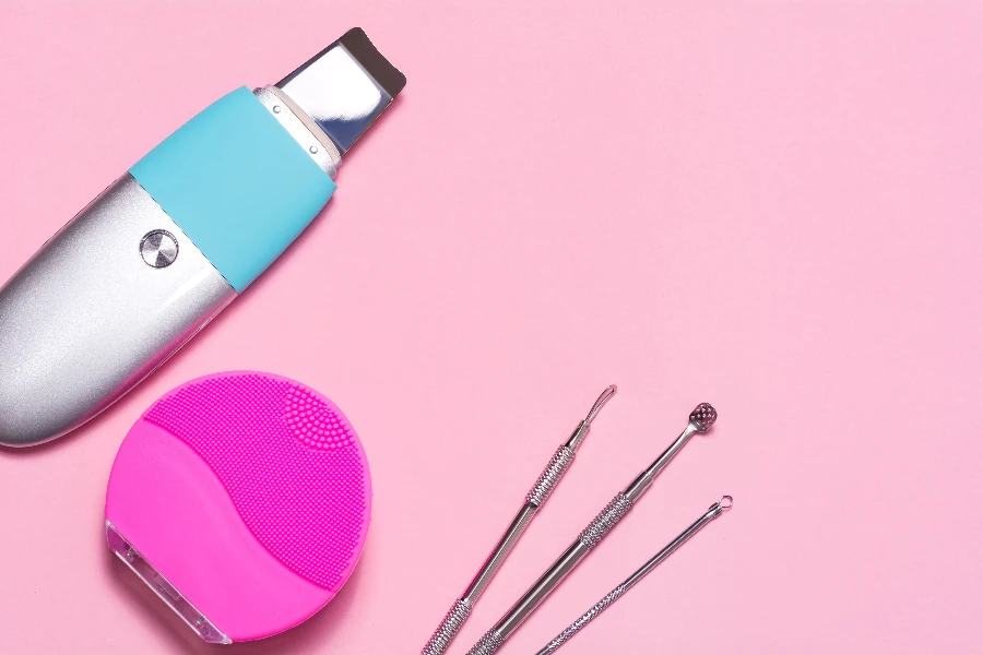 facial cleansing tools on a pink background
