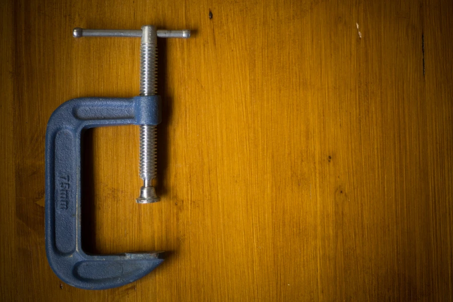 Close up shot of a c-clamp on a wooden background
