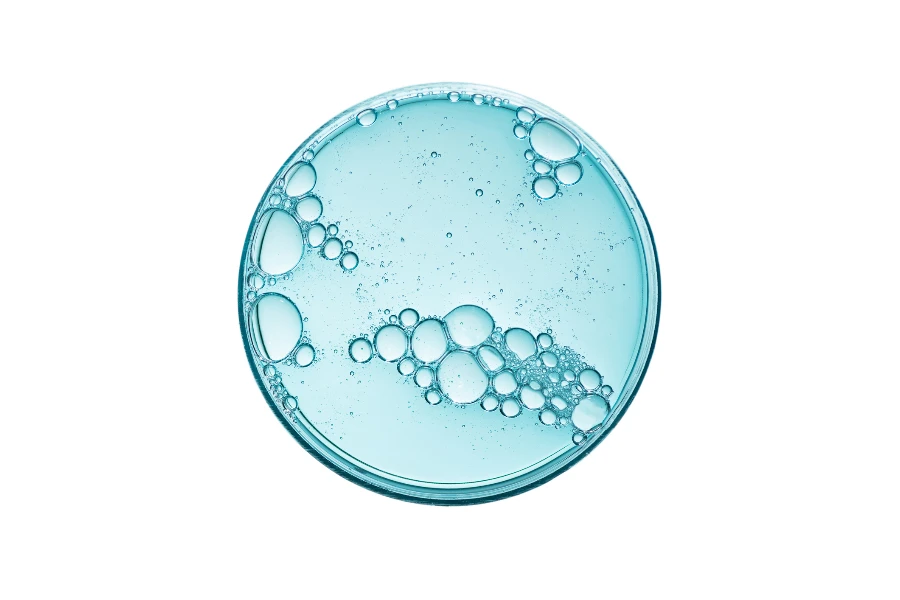 Abstrakte Petrischale mit kosmetischer oder medizinischer Flüssigkeit isoliert auf weißem Hintergrund, Draufsicht