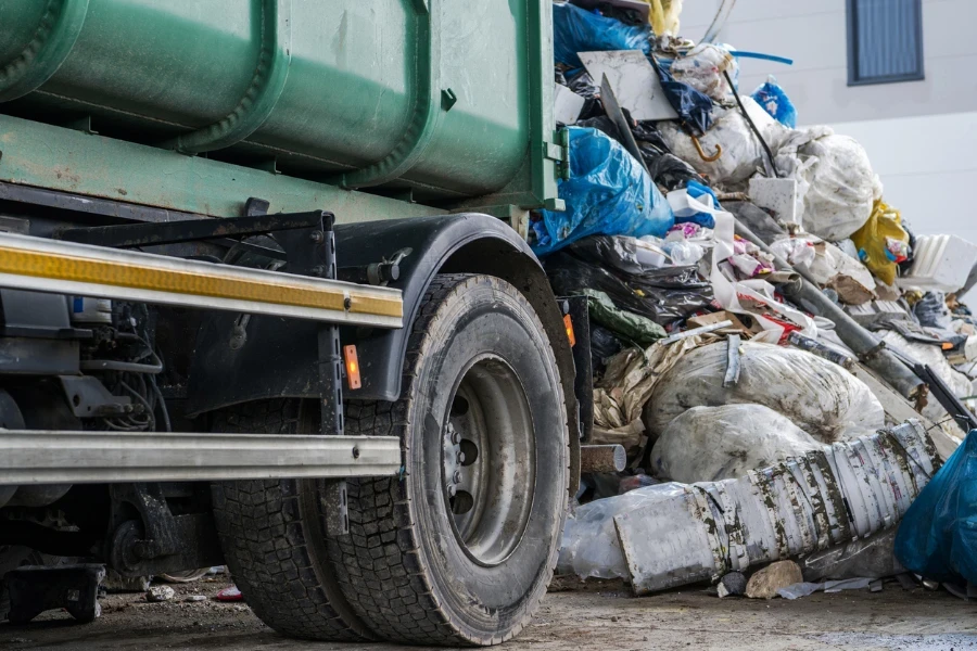 Moderno camion della spazzatura da vicino e il mucchio di spazzatura