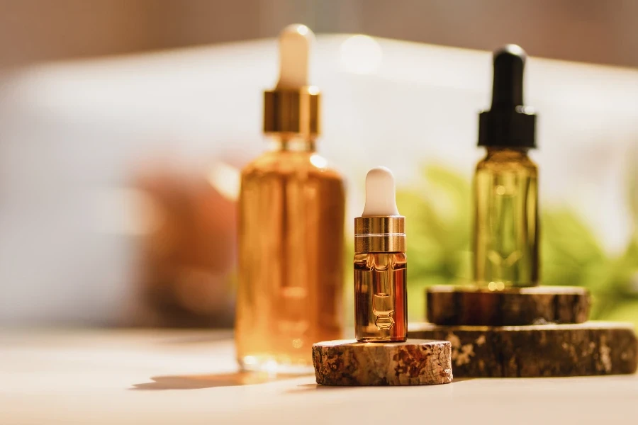 Mockup of glass dropper bottle with a metal cap and yellow essential oil on a background