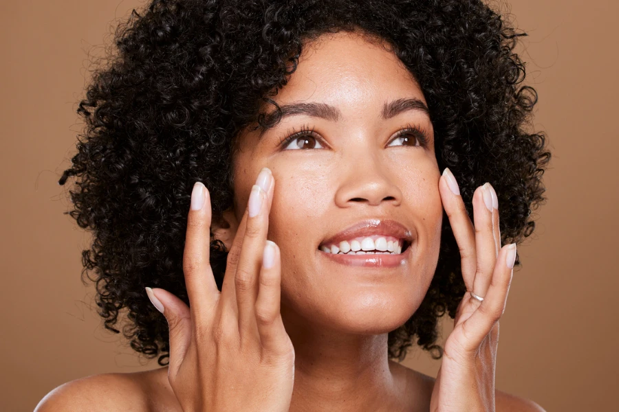 black woman happy about facial wellness creamy matte beige concealer foundation