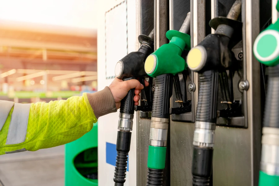Nozel bensin dan solar berwarna-warni dari mesin dispenser di stasiun bahan bakar gas