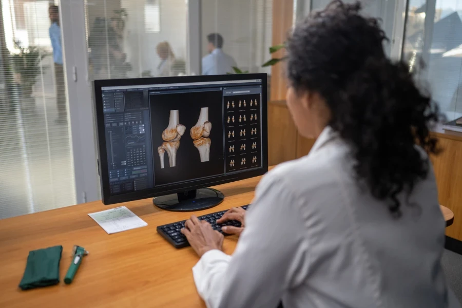 Female doctor examining medical x-rays on computer monitor