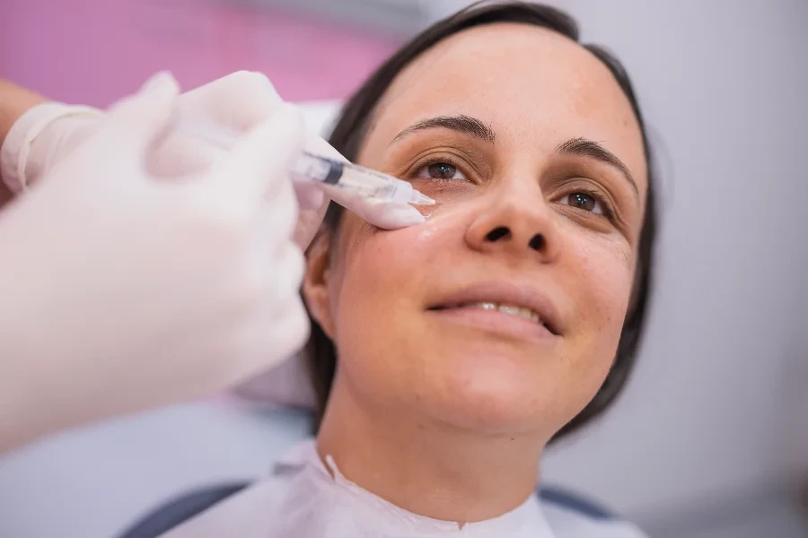 Frau unterzieht sich einer Schönheitsbehandlung für die Region unter den Augen