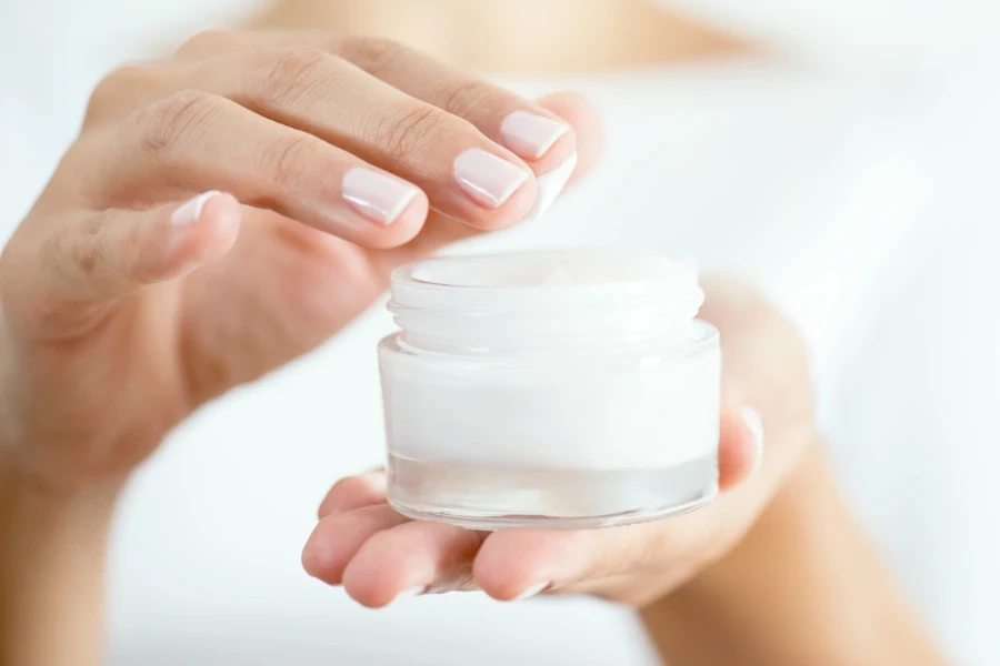 Female hand holding moisturizer in hand
