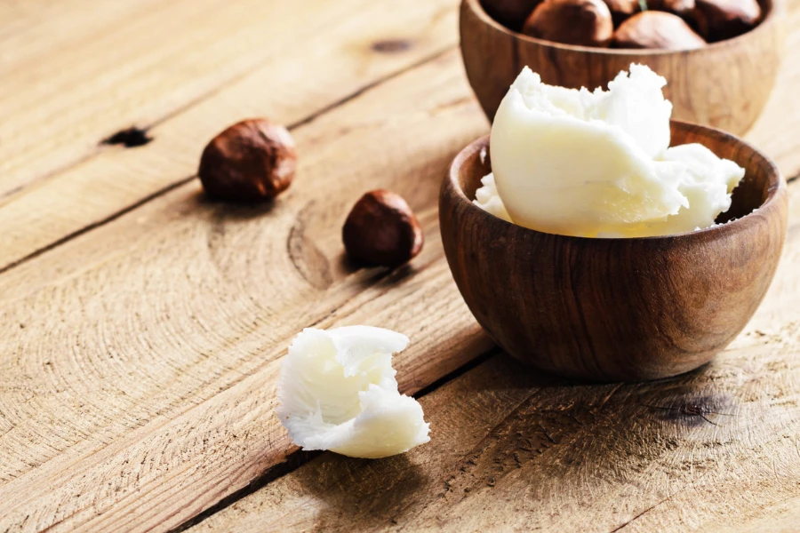 Shea butter and nuts on a wooden board
