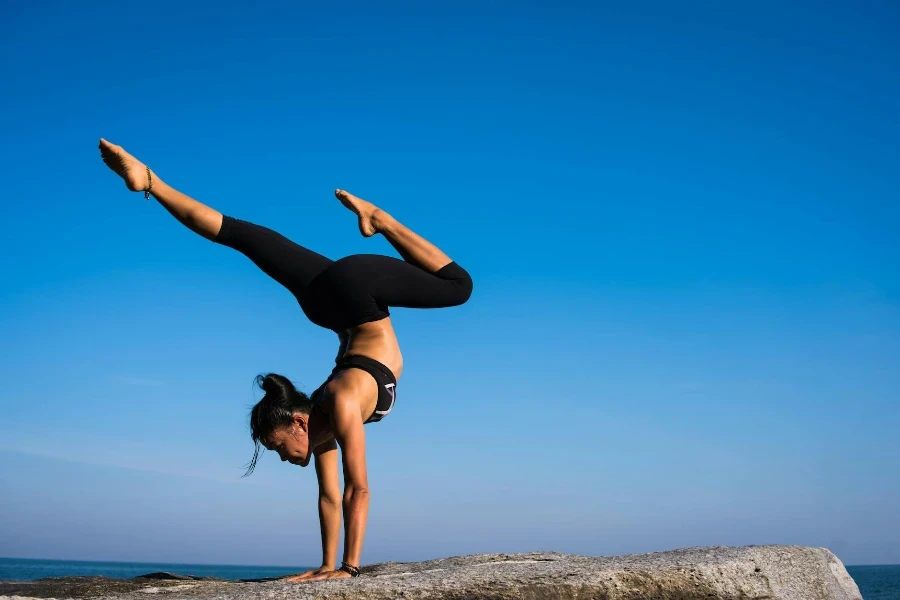 Femme avec les bras tendus contre le ciel bleu