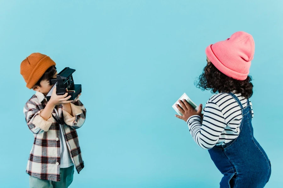 Menino sem rosto tirando foto de menina com cabelo cacheado