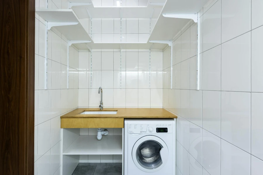Área de lavandería con paredes de azulejos blancos
