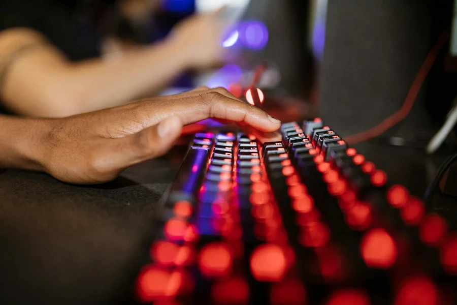 Selektives Fokusfoto der Hand einer Person auf einer mechanischen Tastatur