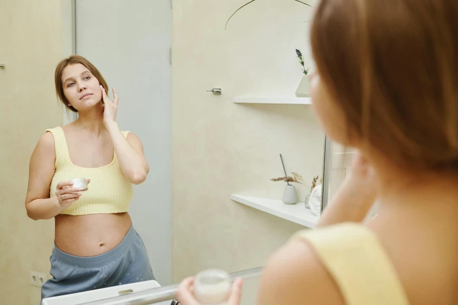 Une femme appliquant une crème pour le visage