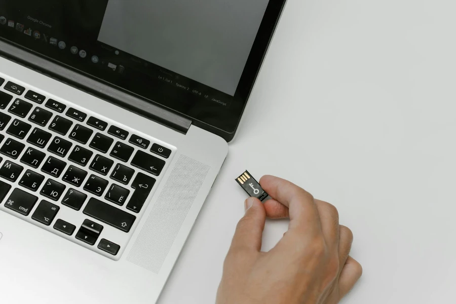 Person Inserting a Memory Card Into a Laptop