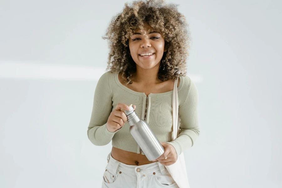 Uma mulher segurando uma jarra de aço inoxidável