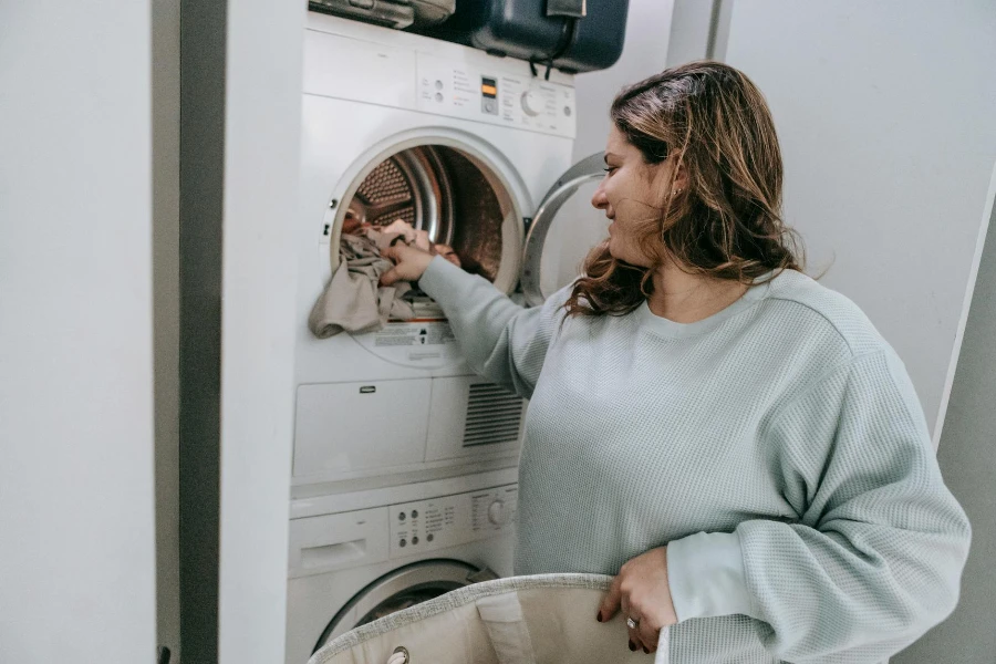 Femme positive chargeant une machine à laver
