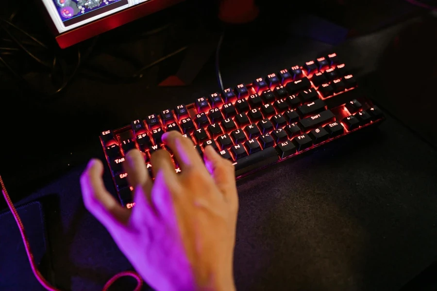 Nahaufnahmefoto der Hand einer Person auf einer mechanischen Tastatur