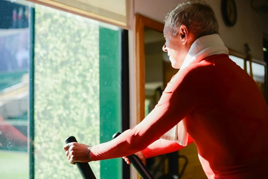 Hombre de mediana edad entrenando en bicicleta estática en el gimnasio