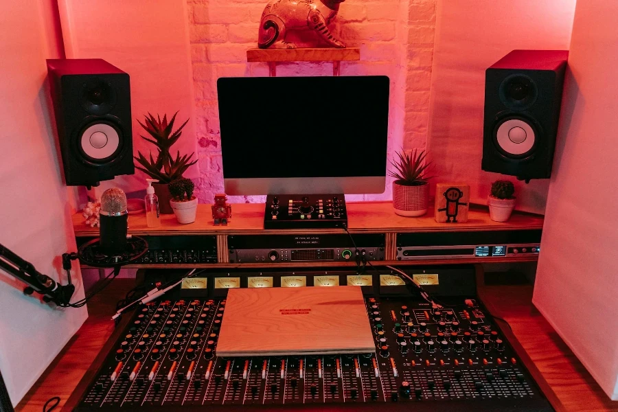 Console de mixage sonore sur bureau avec écran d'ordinateur et haut-parleurs