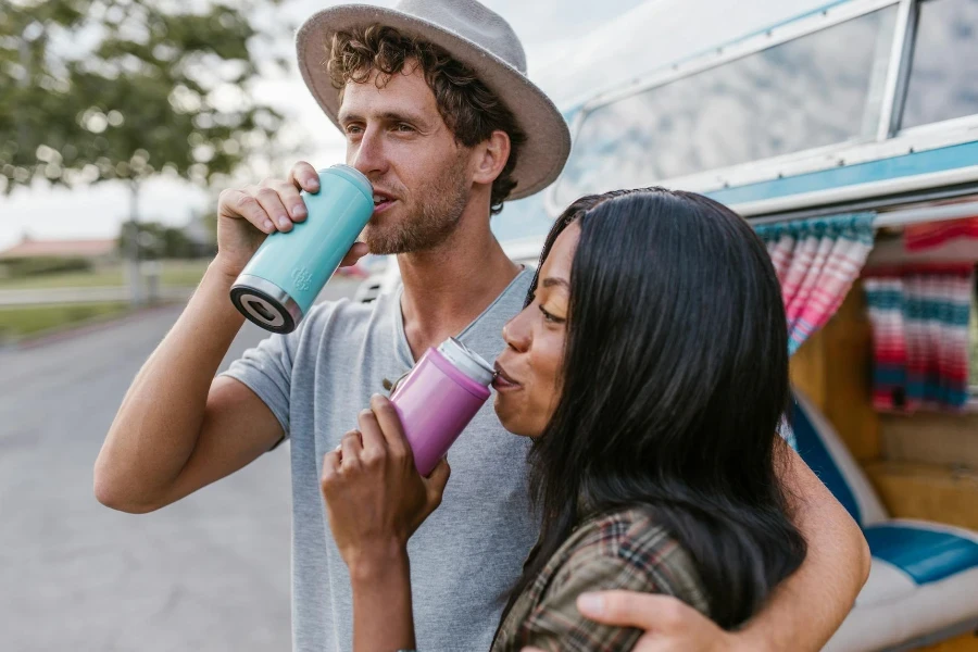 Un hombre y una mujer bebiendo en vasos.