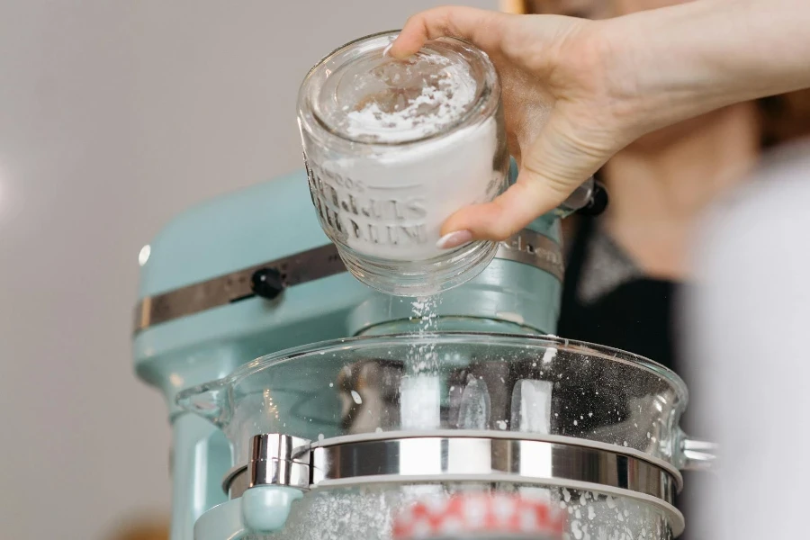 Person Pouring Flour on a Mixer