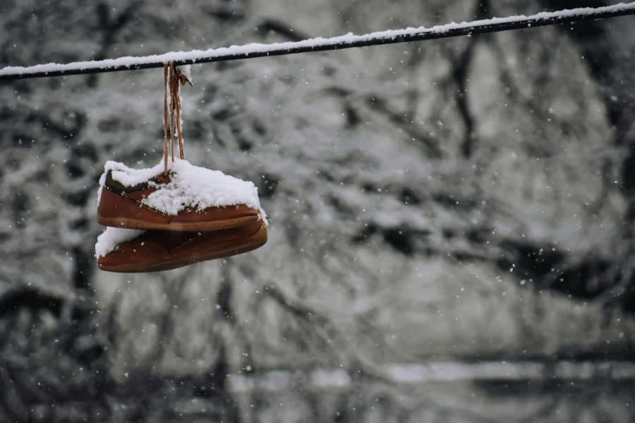 Vieilles bottes accrochées à une corde en journée d'hiver