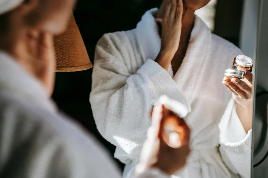 Black woman applying cream in bathroom