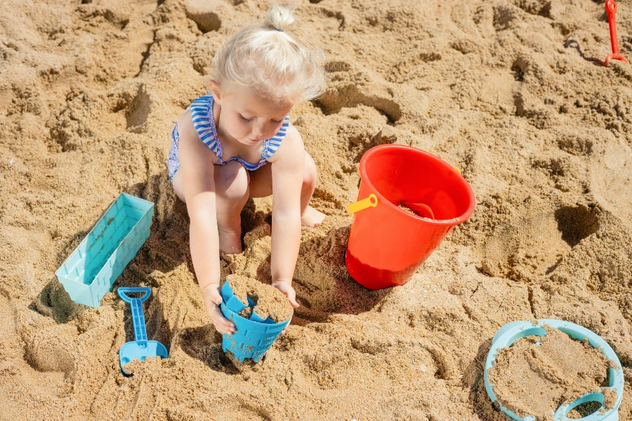 Молодая девушка играет на песчаном пляже