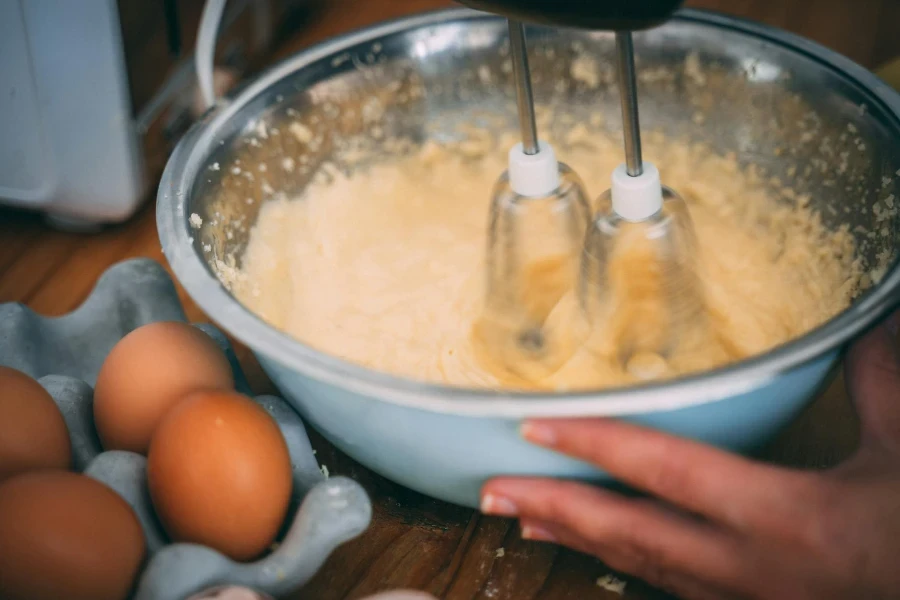 Persona que utiliza una batidora de mano rápida