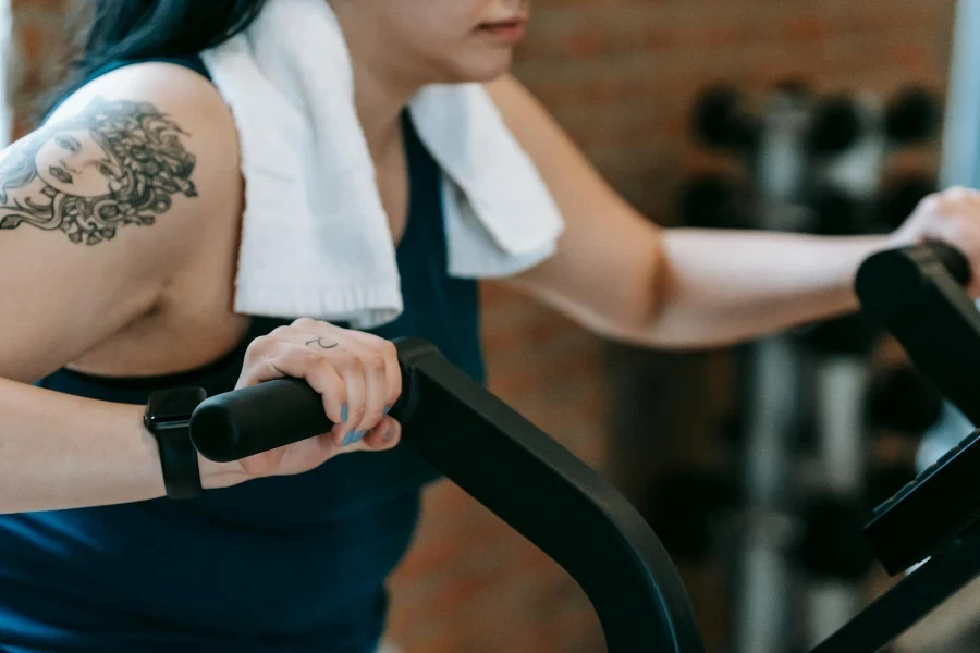 Mujer joven haciendo ejercicios en máquina de ciclismo