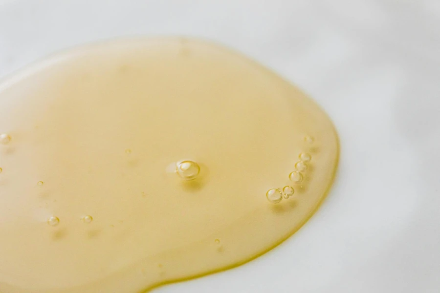 Liquido giallastro trasparente su superficie bianca