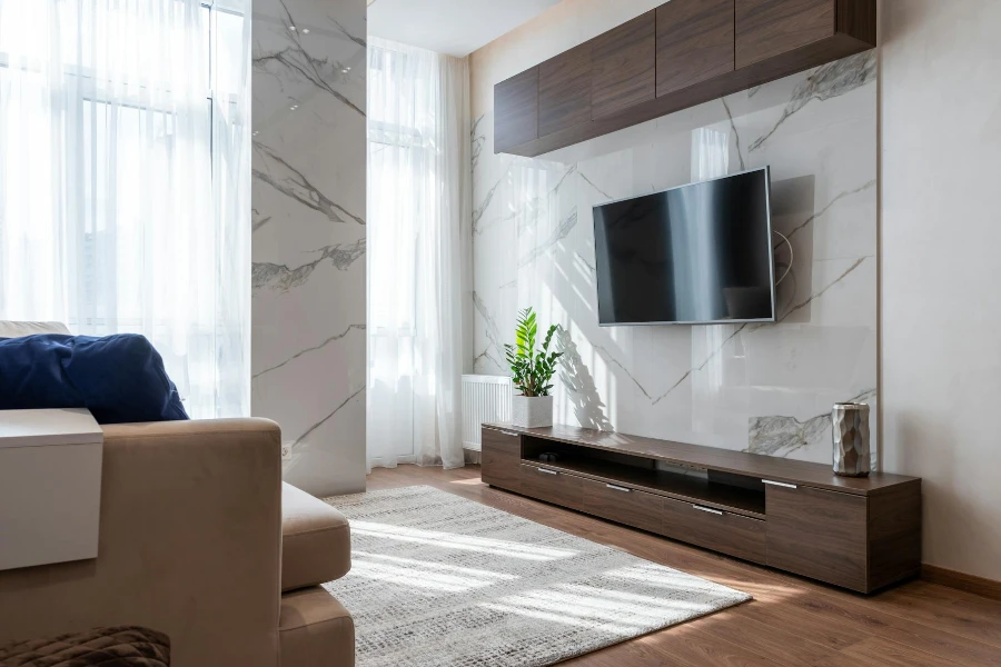 Moderner Fernseher hängt an der Wand zwischen Holzschränken