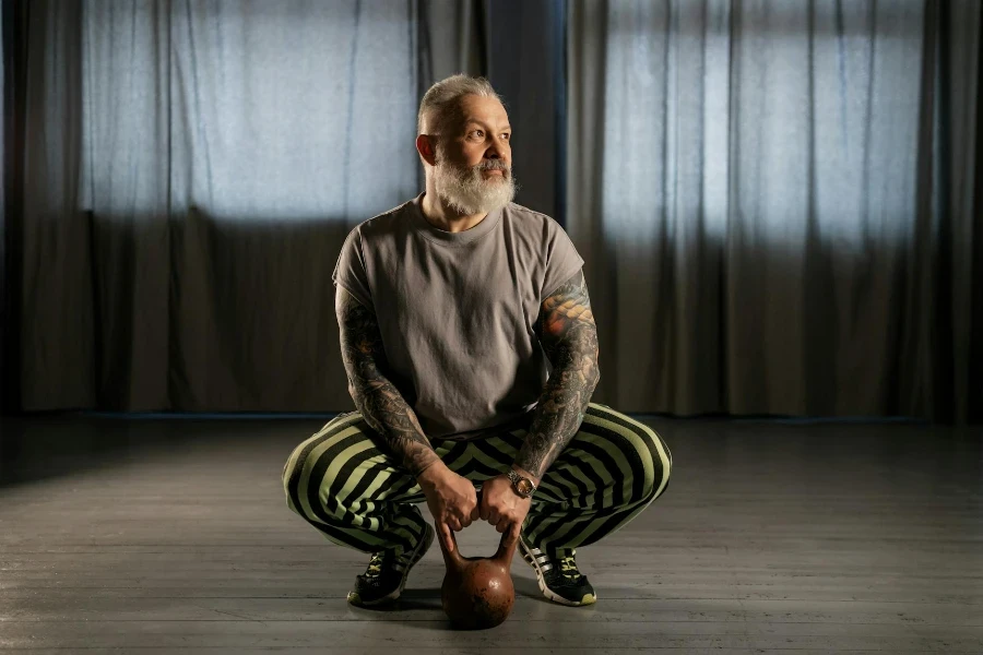 An Elderly Man Holding a Kettlebell