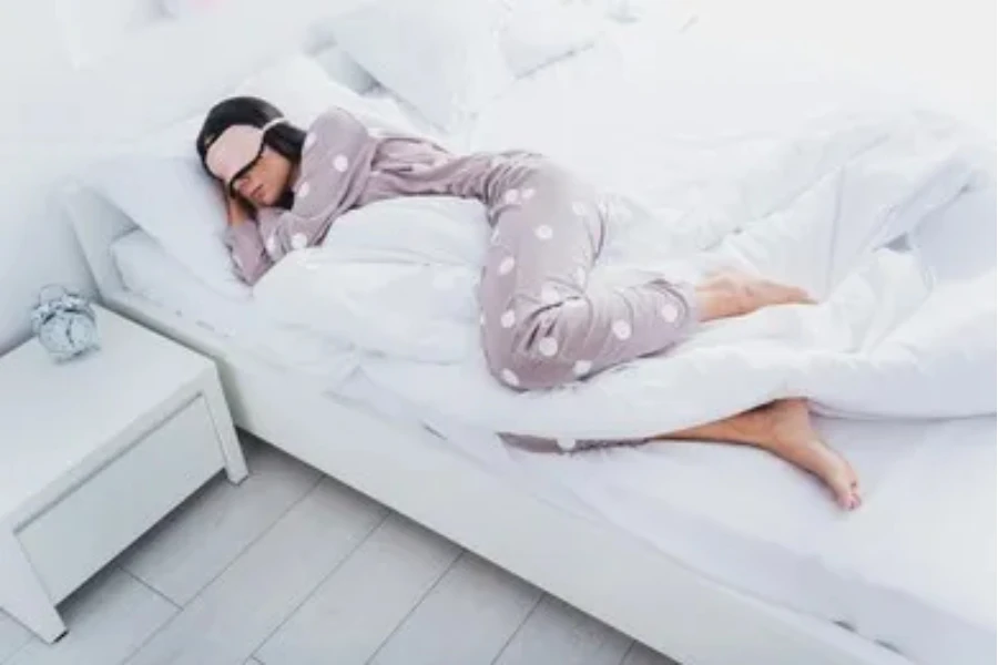 Wanita tidur di tempat tidur dengan pakaian trendi