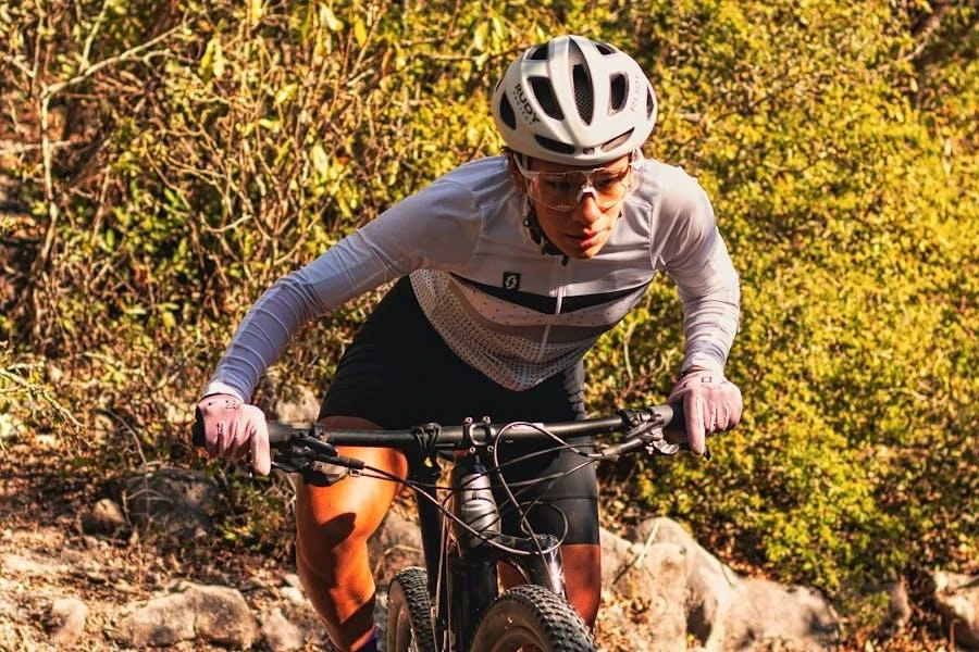 Uomo che guida con una giacca da bicicletta bianca e aderente