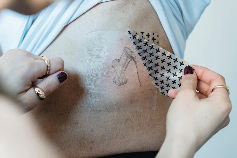 Persona che si fa un tatuaggio temporaneo sulla schiena