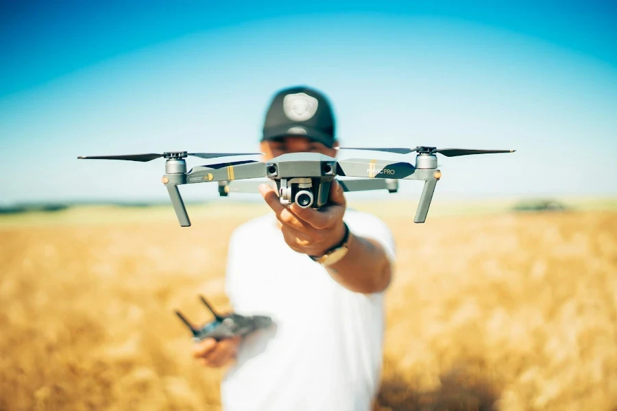 Person in a field holding a drone