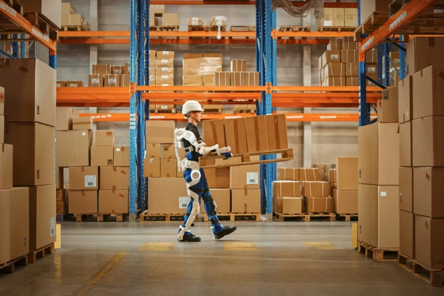 Person wearing an exoskeleton and carrying a box