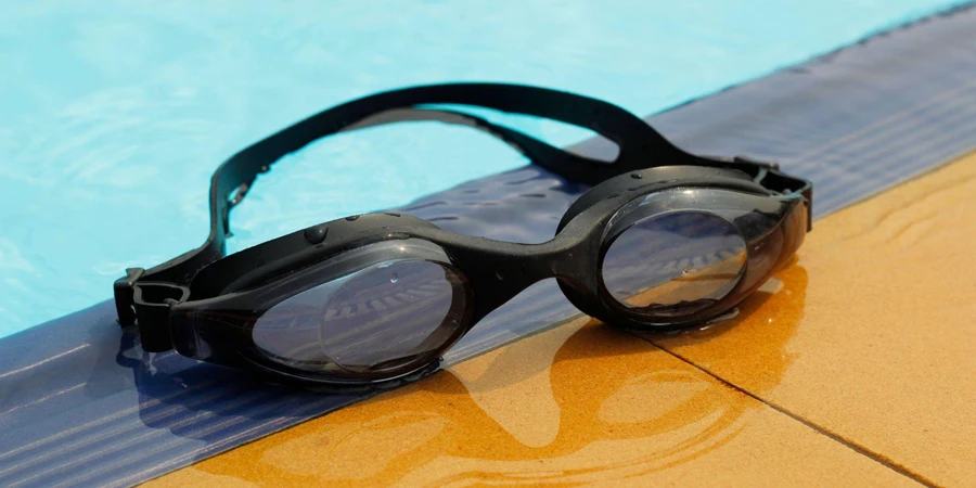occhiali da nuoto accanto alla piscina