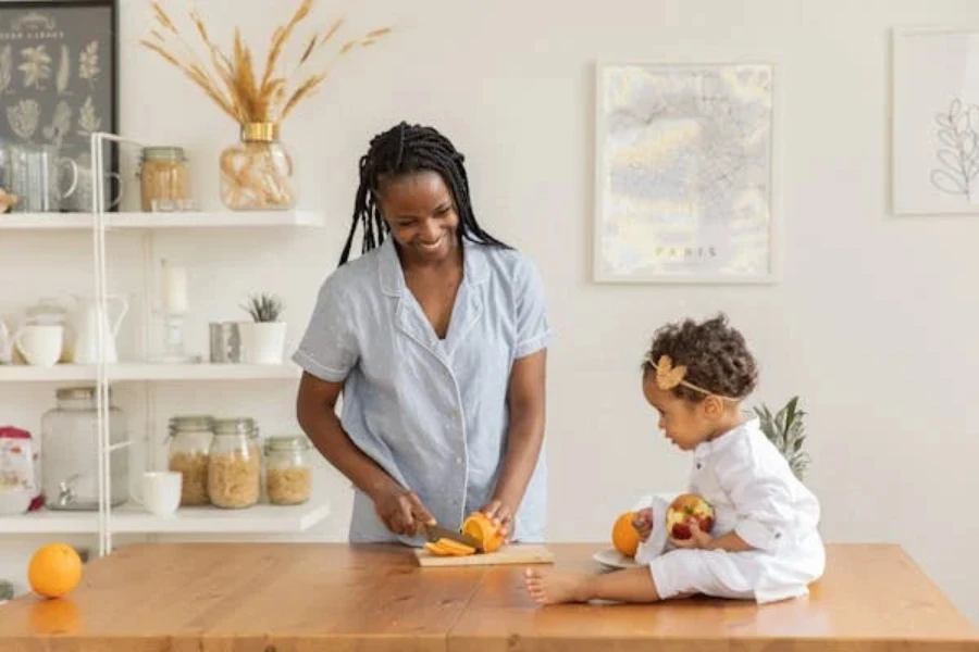 امرأة وطفل يحضران الفاكهة على سطح خشبي