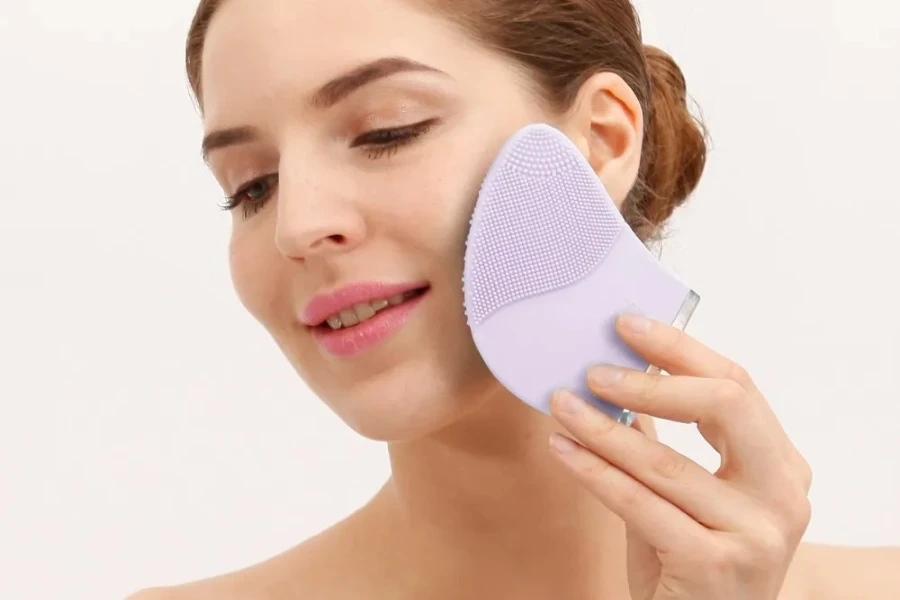 Mujer usando cepillos de limpieza facial manual